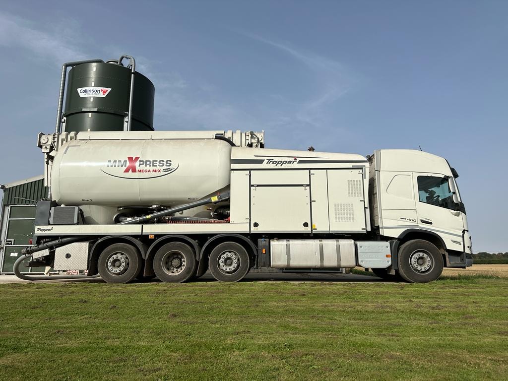 Green Circle Feeds MMXpress Tropper truck parked in a field